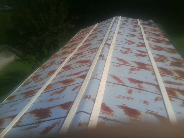 Rusted metal roof panels with new wood purlins before replacement — Storm Damage Roof Repair in Candler by Roofing Brothers