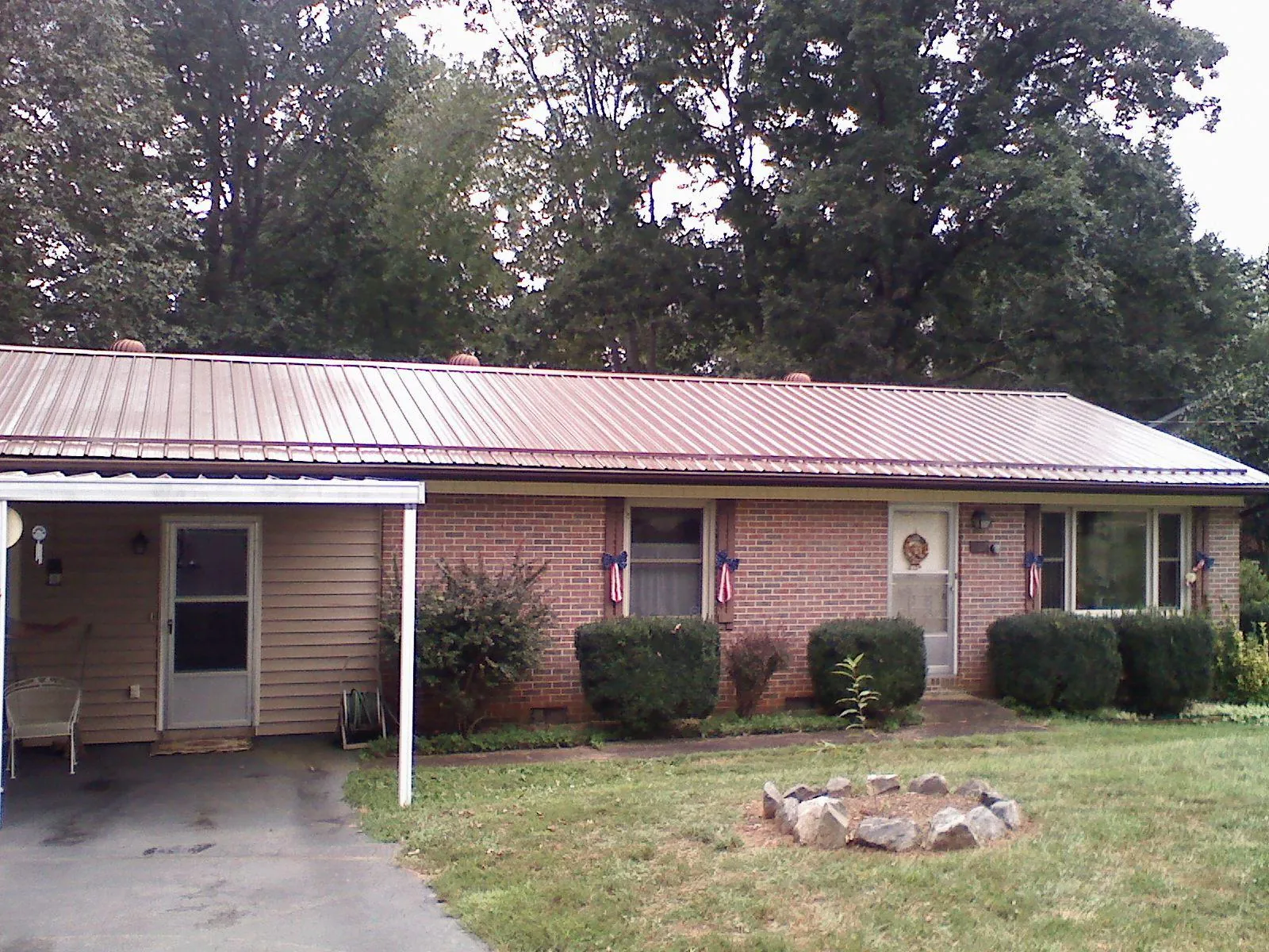 Bronze metal roof and carport on a brick ranch home — Roof Repair work by our crew in Candler