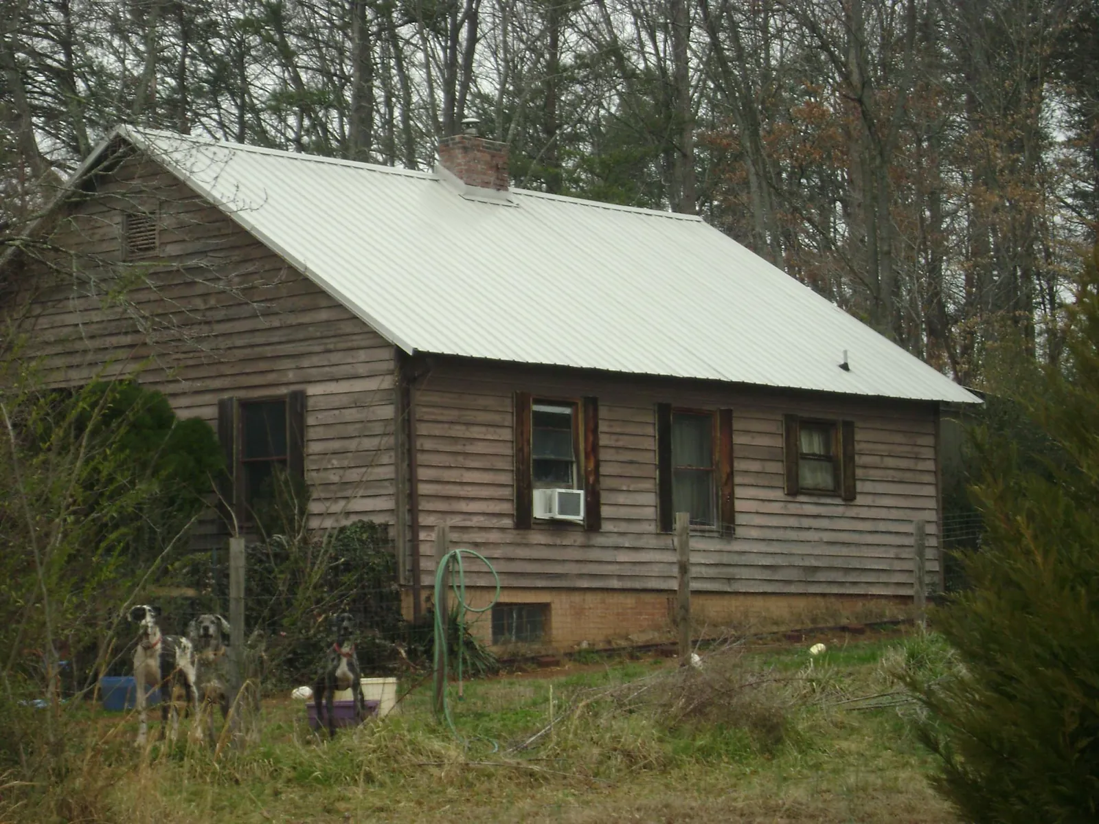 White metal roof on an old wood sided farmhouse, from a Metal Roof Installation job in Candler